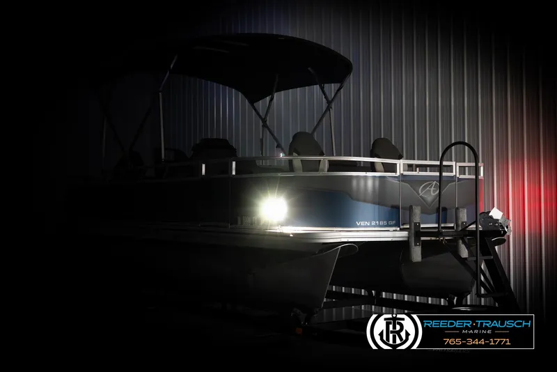 Slide: The Image of 2024 Avalon VEN QF pontoon boat in dimly lit showroom. - 4