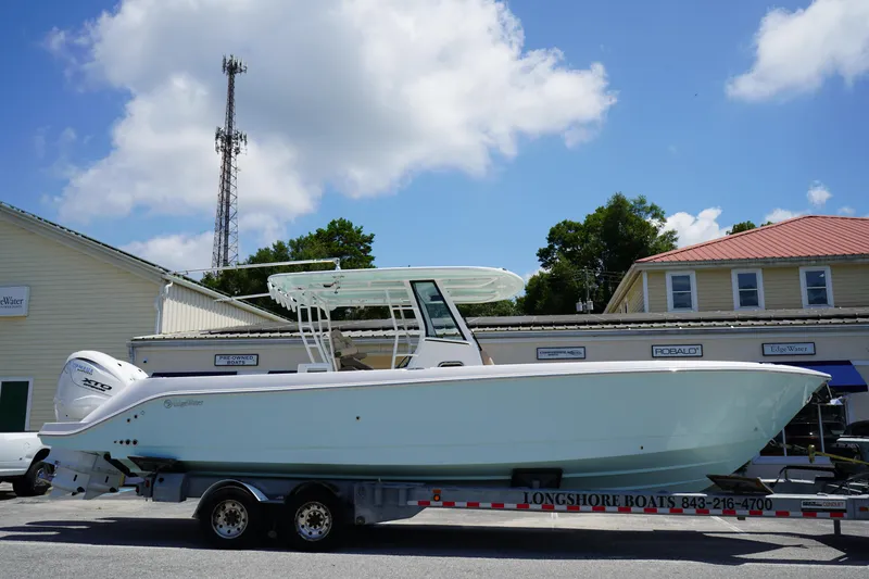 Slide: The Image of 2025 Edgewater 340CC boat on trailer under clear blue sky. - 1
