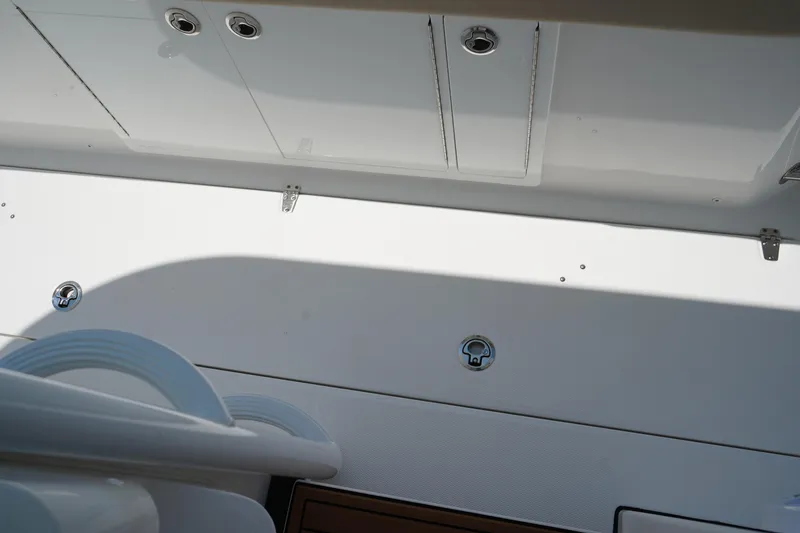 Slide: The Image of 2025 Edgewater 340CC boat storage compartment with sleek white finish and stainless steel handles. - 22