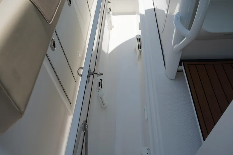 Slide: The Image of Open compartment on 2025 Edgewater 340CC boat showing interior wiring and hinge details. - 45