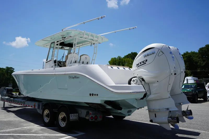 Slide: The Image of 2025 Edgewater 340CC boat with twin Yamaha engines on a trailer under a clear sky. - 7