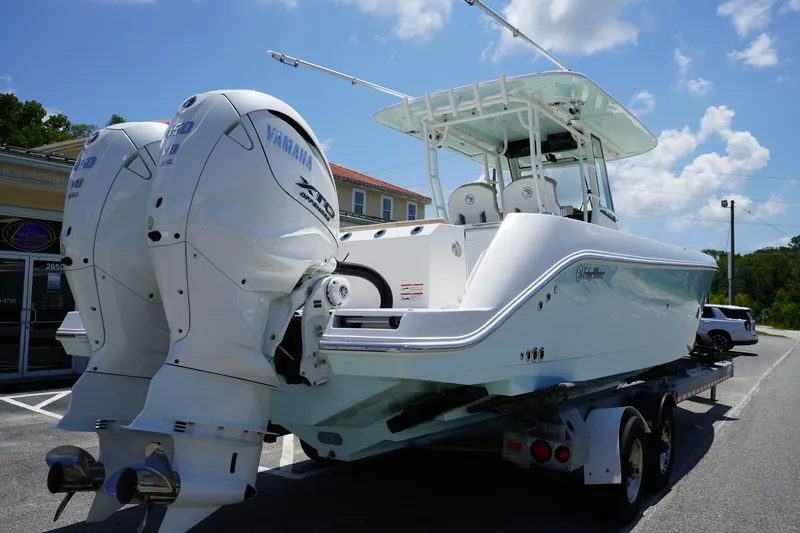 Slide: The Image of 2025 Edgewater 340CC boat interior with rod holders and cushioned seating. - 9