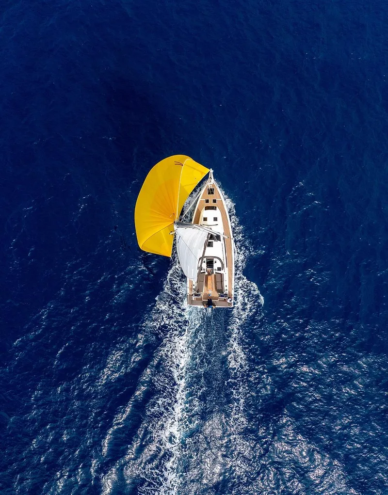 Slide: The Image of Aerial view of 2025 Dufour 41 sailboat with yellow spinnaker on blue ocean. - 6