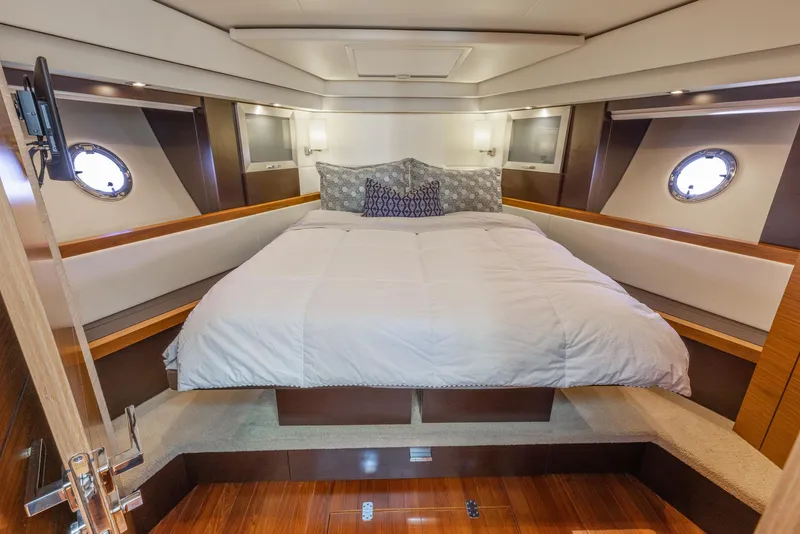 Slide: The Image of Luxurious bedroom interior of 2017 Tiara Yachts 53 Coupe with elegant bedding and porthole windows. - 12