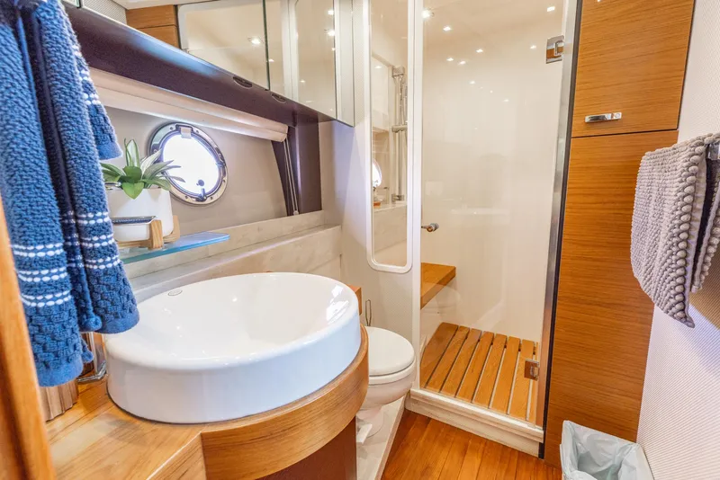 Slide: The Image of Luxurious bathroom in 2017 Tiara Yachts 53 Coupe with modern fixtures and wooden accents. - 15
