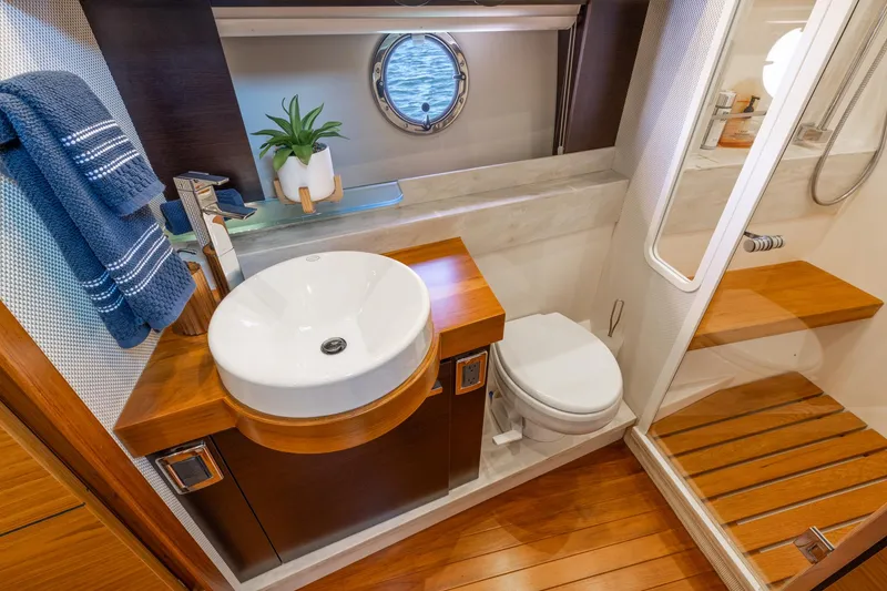 Slide: The Image of Luxurious bathroom in 2017 Tiara Yachts 53 Coupe with modern fixtures and wooden accents. - 16