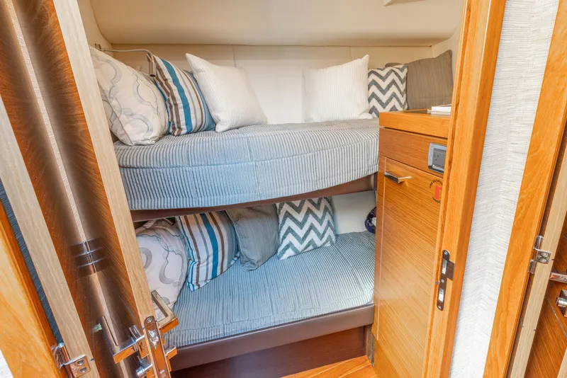 Slide: The Image of 2017 Tiara Yachts 53 Coupe interior with cozy bunk beds and stylish pillows. - 18