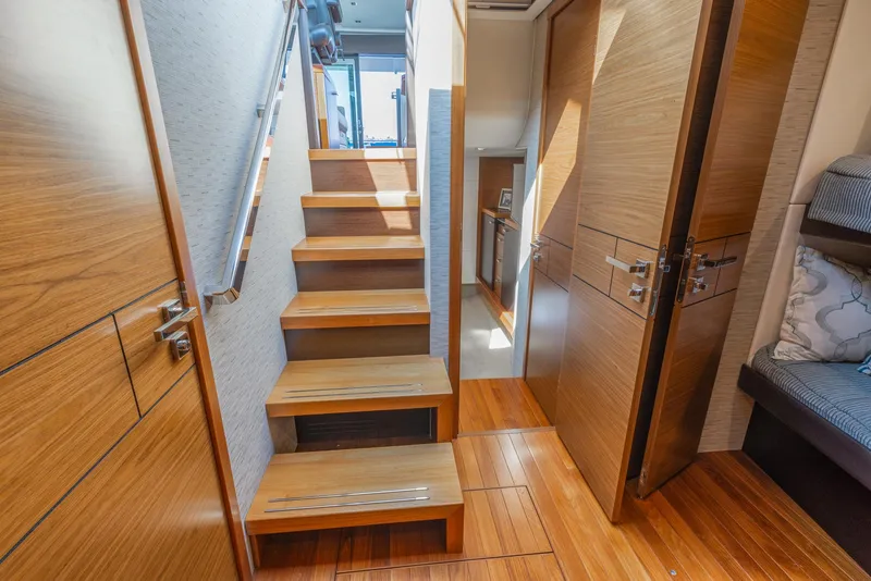 Slide: The Image of Interior of 2017 Tiara Yachts 53 Coupe, featuring wooden stairs and modern design. - 19