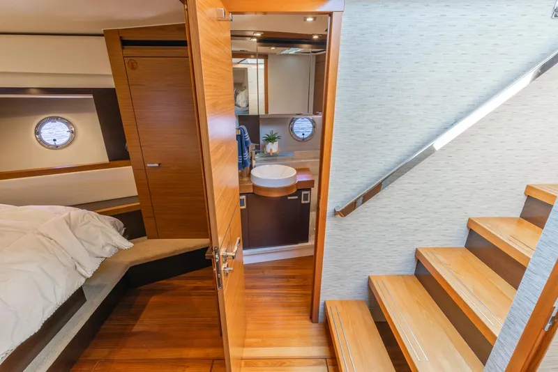 Slide: The Image of Interior of 2017 Tiara Yachts 53 Coupe, featuring bedroom, bathroom, and wooden stairs. - 21