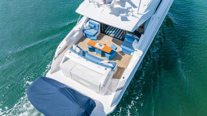Slide: The Image of 2017 Tiara Yachts 53 Coupe cruising on clear blue water, showcasing spacious deck and seating area. - 36