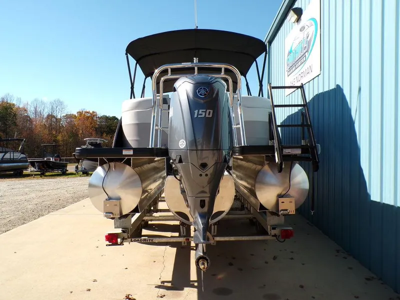 Slide: The Image of 2025 Godfrey Sweetwater 2286 QS boat with 150 HP engine, parked outdoors. - 4