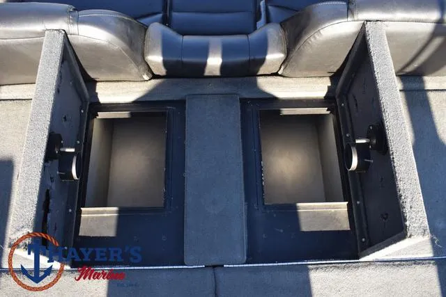Slide: The Image of 1997 Skeeter ZX202C boat storage compartments with open lids, featuring black interior. - 29