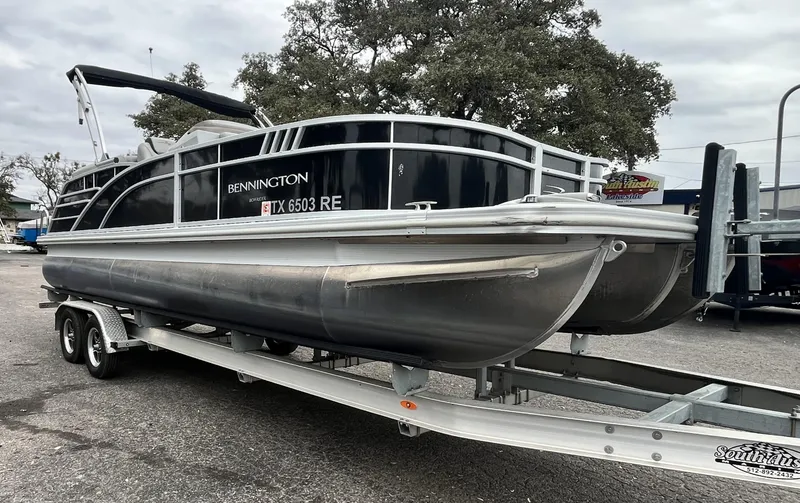 The Image of 2022 Bennington 23LTFB pontoon boat on trailer, parked outdoors. - 0