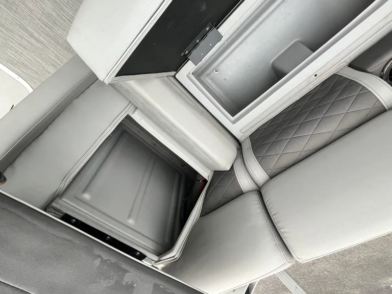 Slide: The Image of 2022 Bennington 23LTFB boat interior storage compartments with gray cushioned seating. - 15