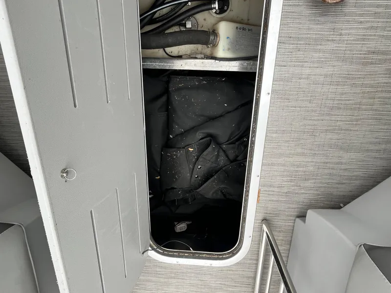 Slide: The Image of Open storage compartment on 2022 Bennington 23LTFB boat with visible interior components. - 21
