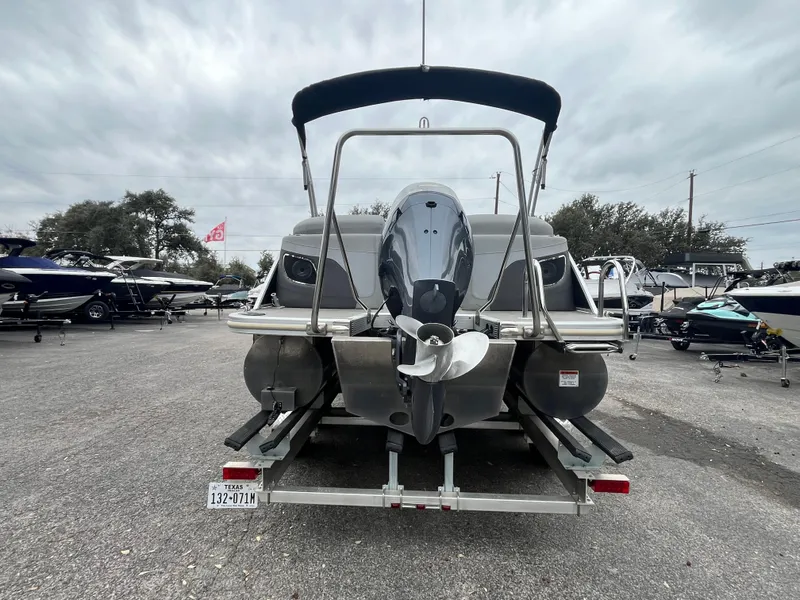 Slide: The Image of 2022 Bennington 23LTFB pontoon boat with outboard motor, parked on trailer. - 3