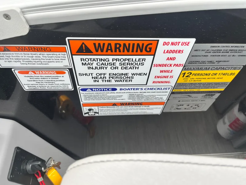 Slide: The Image of Warning labels on 2022 Bennington 23LTFB boat dashboard, safety instructions and capacity limits. - 6