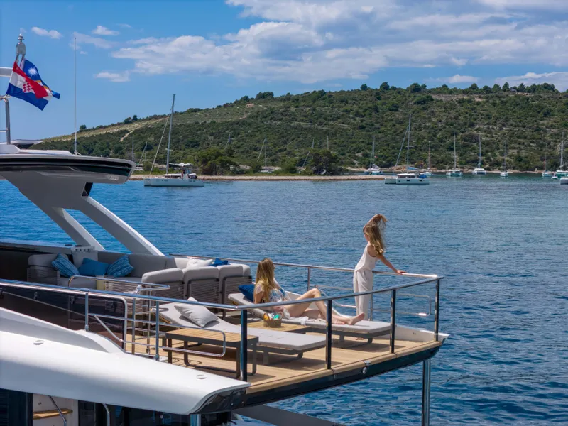 Slide: The Image of Luxury yacht Absolute NAVETTA 75, 2024 model, with people relaxing on deck by the sea. - 13