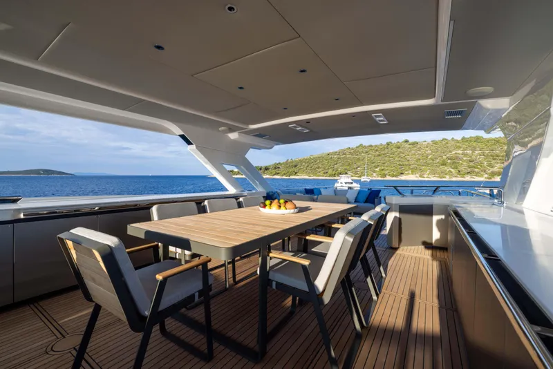 Slide: The Image of Luxurious 2024 Absolute NAVETTA 75 yacht deck with dining area, overlooking serene ocean view. - 33