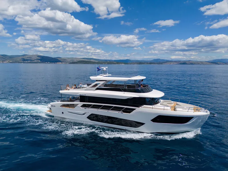 Slide: The Image of 2024 Absolute NAVETTA 75 yacht cruising on open sea under blue skies. - 5
