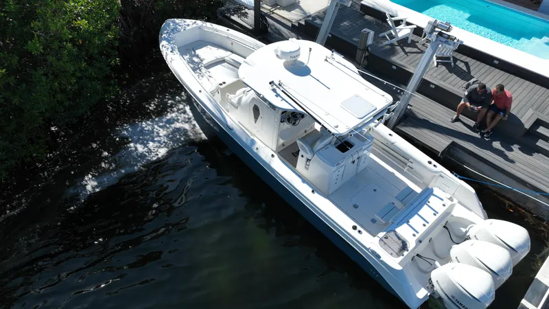 Slide: The Image of 2008 Everglades 350 CC boat docked by a poolside deck. - 1
