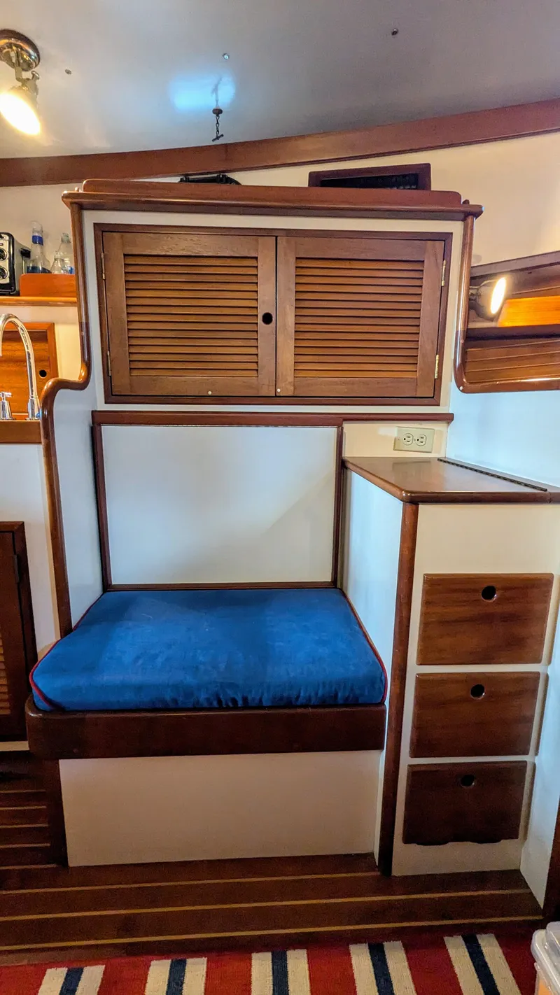 Slide: The Image of Interior of 1990 Stanley Downeast Lobster Yacht with blue cushioned seating and wooden cabinetry. - 28