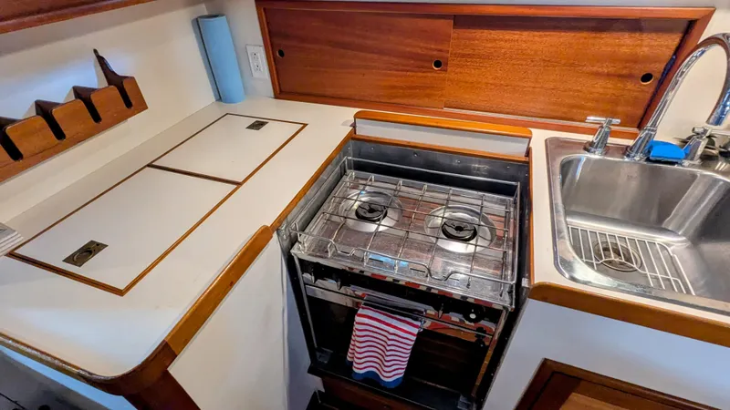 Slide: The Image of Compact kitchen area in a 1990 Stanley Downeast Lobster Yacht with stove and sink. - 29