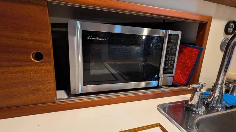 Slide: The Image of Microwave in Stanley Downeast Lobster Boat's kitchen, 1990 model, with sink and red oven mitt. - 30
