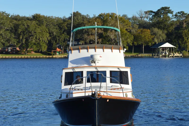 Slide: The Image of 1990 Stanley Downeast Lobster Boat on calm water, surrounded by trees and a dock. - 4