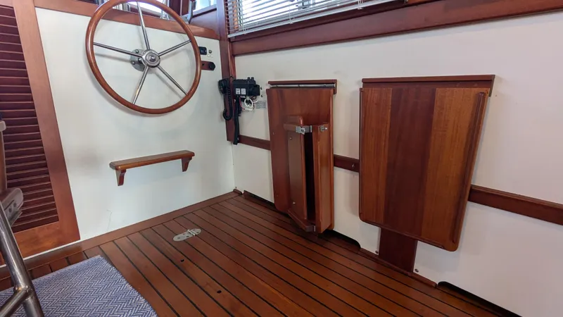 Slide: The Image of Interior of 1990 Stanley Downeast Lobster Yacht with wooden steering wheel and foldable tables. - 47