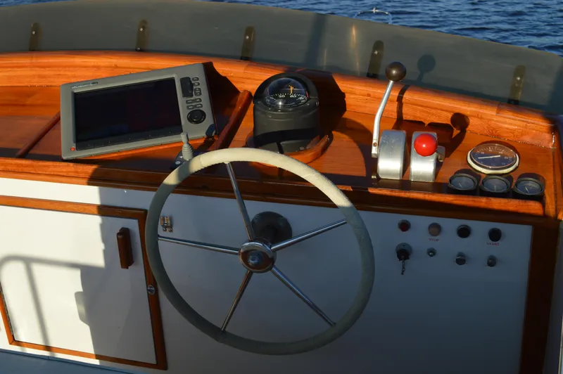 Slide: The Image of 1990 Stanley Downeast Lobster Boat helm with steering wheel, compass, and navigation controls. - 9
