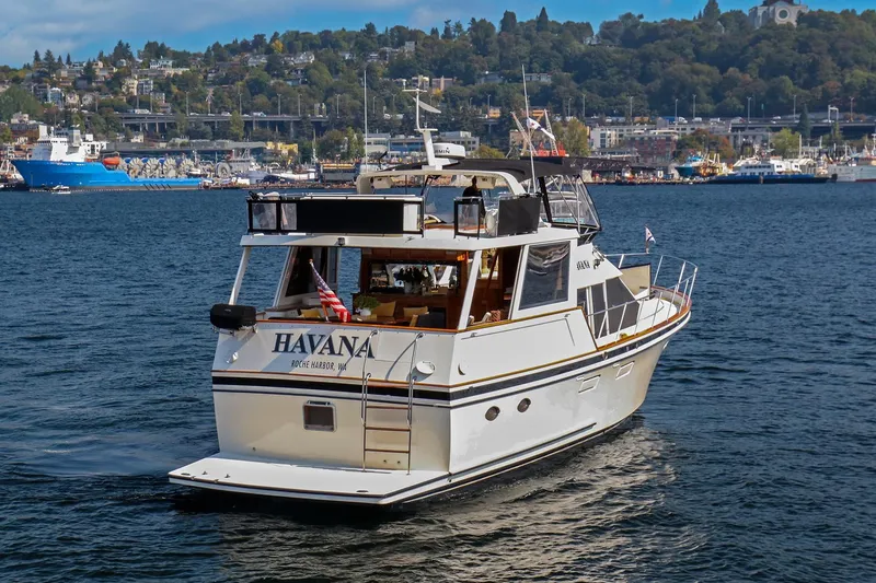 Slide: The Image of 1987 Ocean Alexander Motoryacht cruising in scenic harbor with cityscape background. - 1