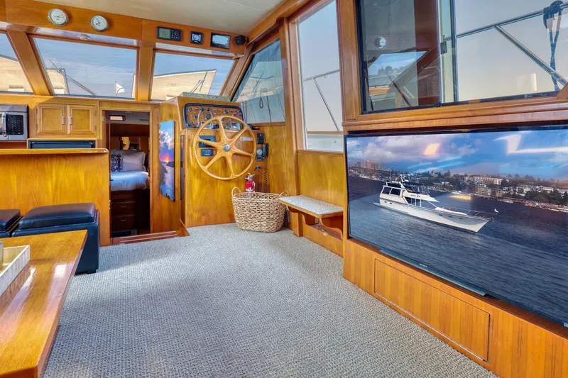 Slide: The Image of 1987 Ocean Alexander Motoryacht interior with wooden helm, cozy cabin, and large window view. - 10