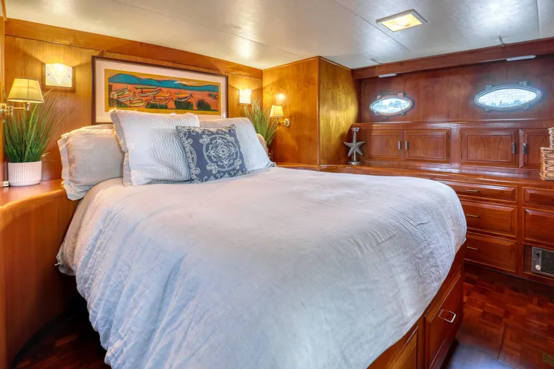 Slide: The Image of Luxurious 1987 Ocean Alexander Motoryacht bedroom with elegant wood paneling and cozy bedding. - 13