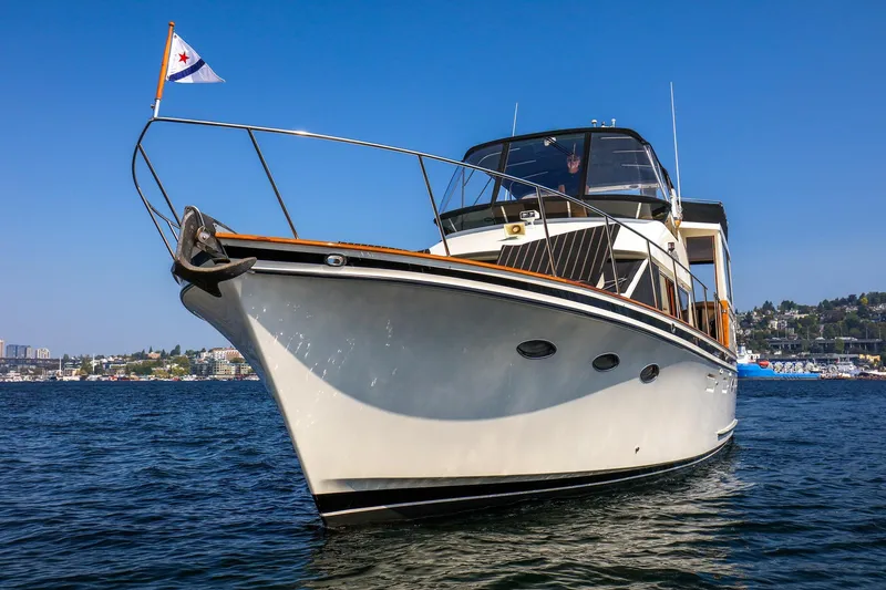 Slide: The Image of 1987 Ocean Alexander Motoryacht on water, clear sky, cityscape background. - 2