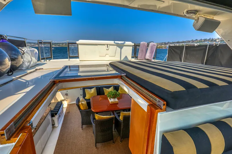 Slide: The Image of Luxurious 1987 Ocean Alexander Motoryacht with elegant outdoor seating and striped sunbed. - 5