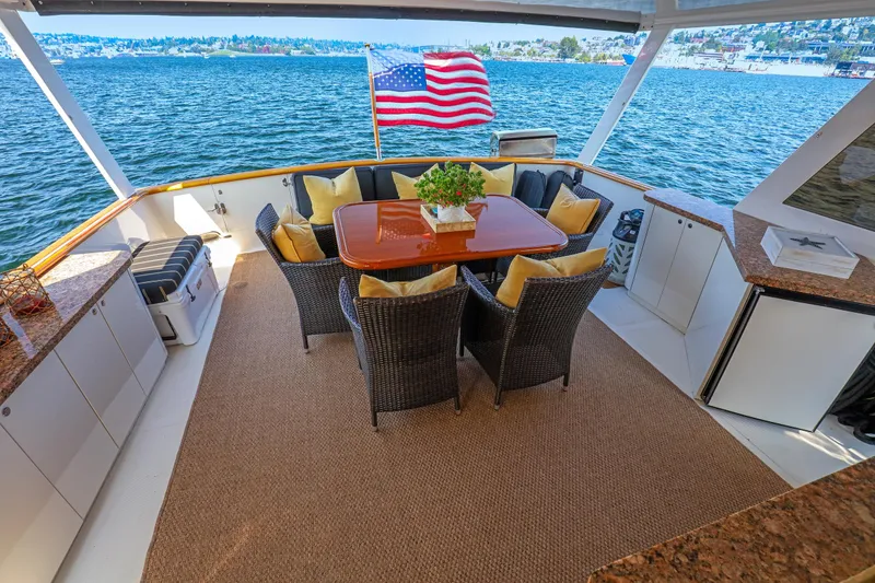Slide: The Image of Luxurious 1987 Ocean Alexander Motoryacht deck with dining area and scenic water view. - 6