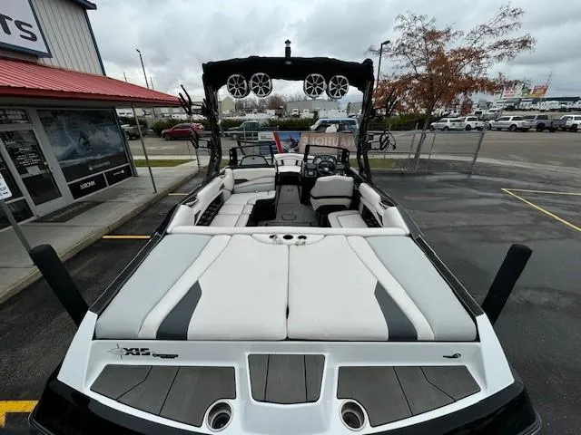 Slide: The Image of 2018 Axis A22 boat with spacious seating and modern design in a parking lot. - 11