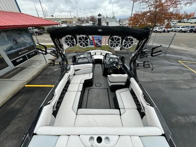 Slide: The Image of 2018 Axis A22 boat interior with white seating and mounted speakers. - 12