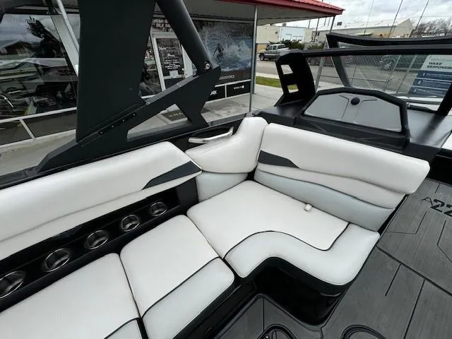 Slide: The Image of 2018 Axis A22 boat interior with white cushioned seating and cup holders. - 16