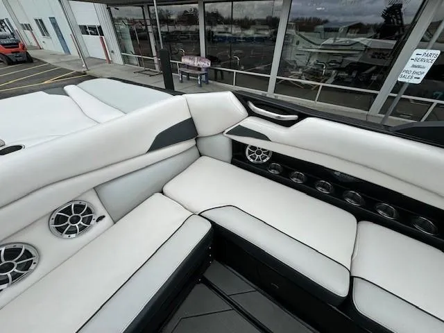 Slide: The Image of 2018 Axis A22 boat interior with white seating and built-in speakers. - 18