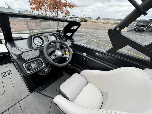 Slide: The Image of Interior of 2018 Axis A22 boat, featuring steering wheel, gauges, and comfortable seating. - 19