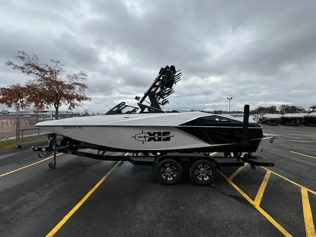 Slide: The Image of 2018 Axis A22 boat on trailer in parking lot, cloudy sky background. - 7