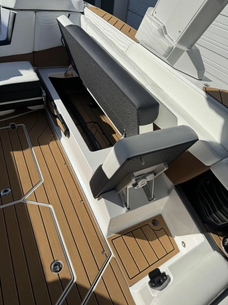 Slide: The Image of 2025 Nautique Super Air Nautique G25 interior with open storage compartment and teak flooring. - 12