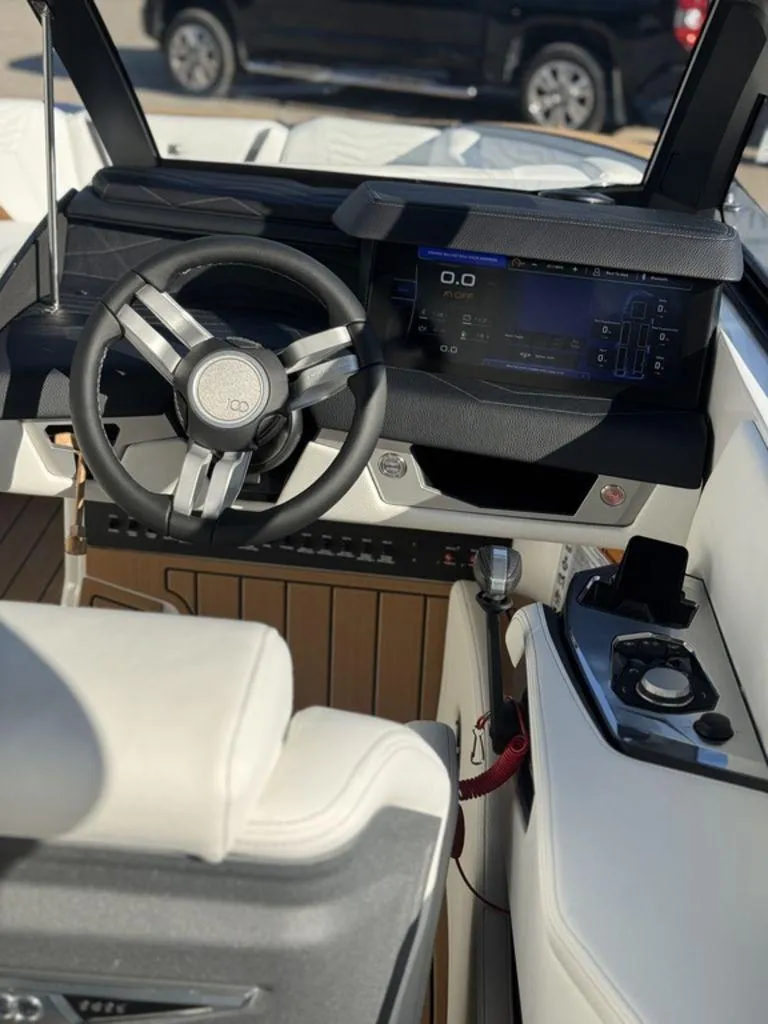 Slide: The Image of 2025 Nautique Super Air Nautique G25 boat interior with modern dashboard and steering wheel. - 16
