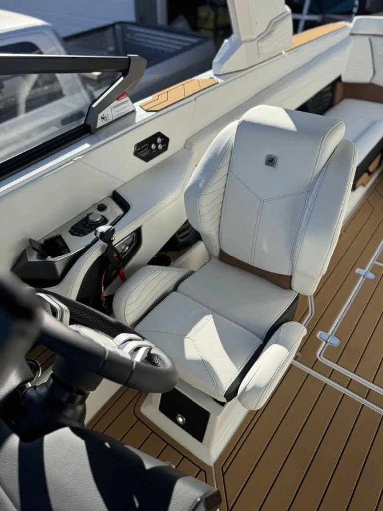 Slide: The Image of 2025 Nautique Super Air Nautique G25 interior with luxurious white seating and modern controls. - 18