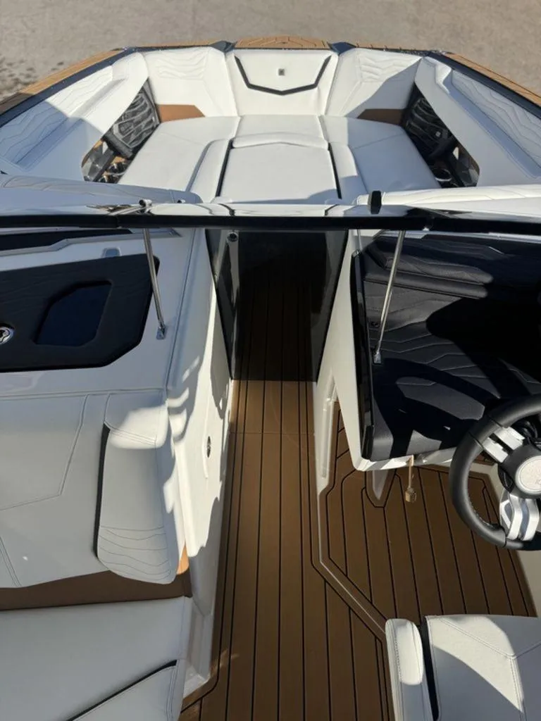 Slide: The Image of 2025 Nautique Super Air Nautique G25 interior with white seating and wooden flooring. - 24