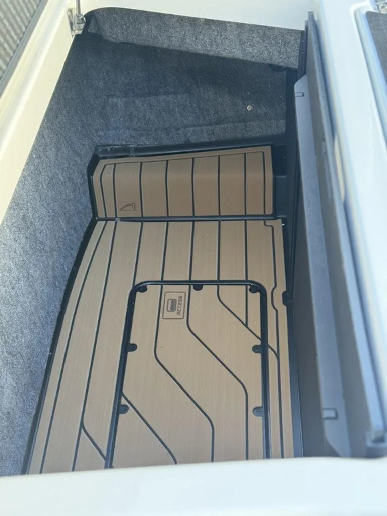 Slide: The Image of 2025 Nautique Super Air Nautique G25 storage compartment with custom flooring. - 7