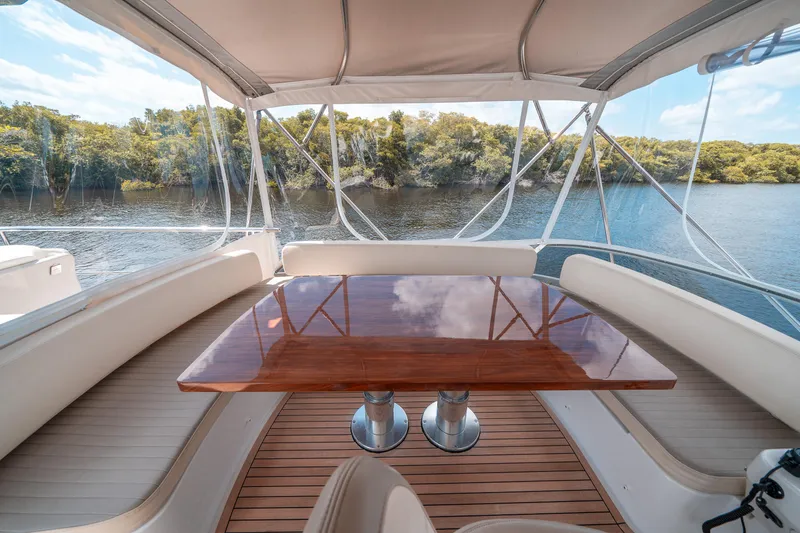 Slide: The Image of Luxurious 2018 Azimut Magellano 53 yacht deck with elegant wooden table and scenic water view. - 13