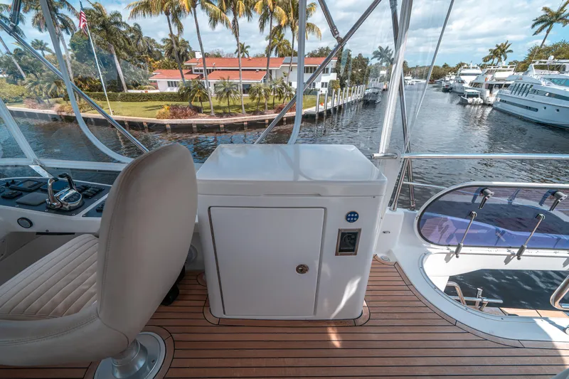 Slide: The Image of Azimut Magellano 53 yacht deck with seating, 2018 model, overlooking a scenic marina. - 22